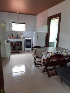 Casa Lumiar في لوميار: مطبخ مع طاولة ومطبخ مع أجهزة بيضاء