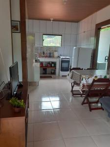 Una cocina con electrodomésticos blancos y una mesa en ella. en Casa Lumiar, en Lumiar