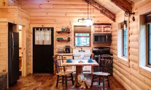 a kitchen with a table and chairs in a cabin at Treehouse #6 by Amish Country Lodging in Millersburg