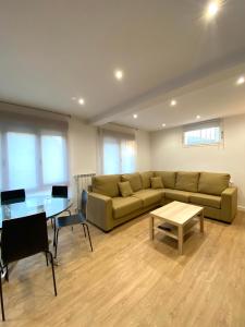 a living room with a couch and a table at Apartamentos el Oligo in Cadavedo