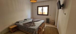 a small bedroom with a bed and a window at FRESH DESIGNED next to THE SEA -nice area - wifi in Essaouira