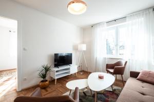 a living room with a couch and a tv and a table at OMA's Apartment in Haus GRETE in Bad Waltersdorf