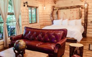 ミラーズバーグにあるTreehouse #7 by Amish Country Lodgingのベッドルーム(ベッド1台、革張りのソファ付)