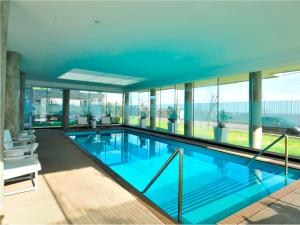 uma grande piscina com água azul num edifício em Real Colonia Hotel & Suites em Colônia do Sacramento