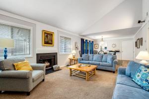a living room with blue couches and a fireplace at Oceanwoods 452 in Kiawah Island