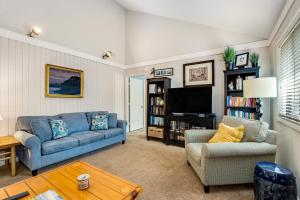 a living room with a couch and a tv at Oceanwoods 452 in Kiawah Island