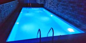 a large swimming pool with blue lights in it at Premium apartman Family in Paralia Katerinis