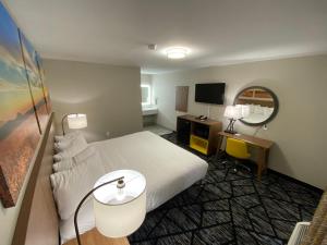 a hotel room with a bed and a television at Days Inn by Wyndham Lake Charles in Lake Charles