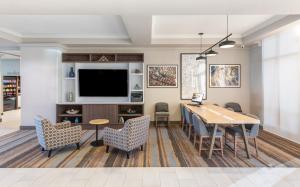 a living room with a table and chairs and a television at Holiday Inn Hotel & Suites - Orange Park - Wells Rd. in Orange Park