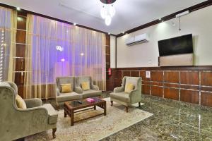 Una sala de estar con dos sillas y un televisor de pantalla plana. en فندق بفن Puffin Hotel, en Al Nairyah 17 fotos más