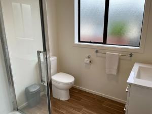 Un baño con inodoro, lavabo y ventana. en 42 Scarborough Tce, en Hanmer Springs 10 fotos más