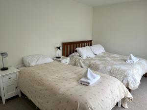 Un dormitorio con dos camas con toallas blancas encima. en 42 Scarborough Tce, en Hanmer Springs
