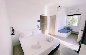 a white bedroom with a bed and a bathroom at Alkyon Hotel in Parikia