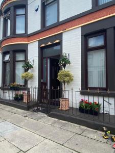 a house with potted plants on the front door at SureScape House in Liverpool