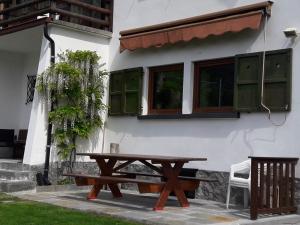 a picnic table in front of a house at Villa Bianca Bormio garden and parking in Premadio