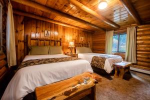 um quarto com 2 camas num chalé de madeira em The Hatchet Resort em Moran