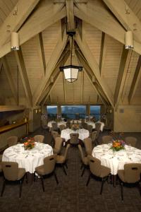 a banquet hall with white tables and chairs and a chandelier at Timberline Lodge in Government Camp