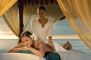 a woman laying on a bed next to another woman at Dreams Cozumel Cape Resort & Spa in Cozumel