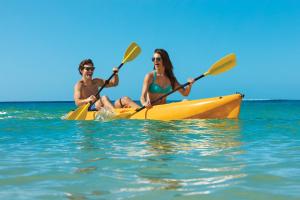 a man and a woman in a yellow kayak in the water at Dreams Cozumel Cape Resort & Spa in Cozumel