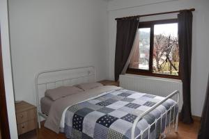 - une chambre avec un lit doté d'une couverture en damier et d'une fenêtre dans l'établissement Moutoullas Apartment, à Nicosie