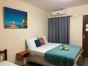 Habitación hospitalaria con cama con manta verde en Pousada Âncora Pipa en Pipa