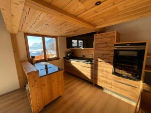 a kitchen with wooden cabinets and a stove top oven at Panorama Penthouse mit Sauna & großem Balkon in Gallzein