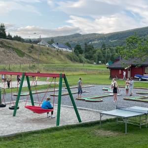 eine Gruppe von Menschen, die auf einem Spielplatz spielen in der Unterkunft Sandviken Camping in Austbygdi