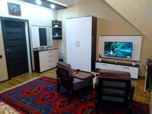 a living room with two chairs and a tv at Dom Semya Deluxe Gusar in Qusar