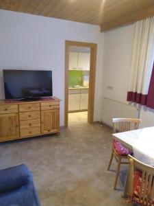 a living room with a flat screen tv on a wooden dresser at Tischlerhof in Achensee