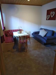 a living room with a blue couch and a table at Tischlerhof in Achensee