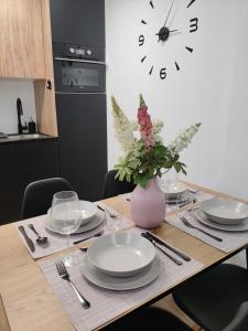 een eettafel met borden en een vaas met bloemen bij New Apartment Claret in Xàtiva