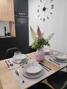 a dining room table with plates and a vase with flowers at New Apartment Claret in Xàtiva +24 photos
