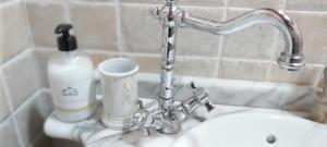 a metal faucet over a toilet in a bathroom at Casa de Lela in Negreira