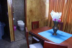 een eettafel met een vaas met bloemen erop bij Hostal Flor de los Ángeles in Guamote
