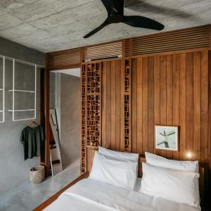 a bedroom with a bed with a wooden wall at Tamni in Bangkok