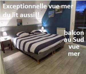 een slaapkamer met een bed met een blauwe muur bij Grand LARGE FACE A LA PLAGE TRESTEL in Trévou-Tréguignec