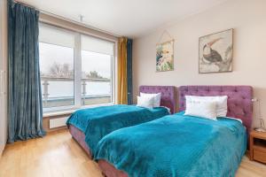 2 camas en una habitación con ventana en Aquamarina Międzyzdroje Marina Invest, en Międzyzdroje