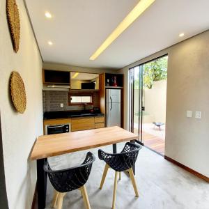 a kitchen with a wooden table and two chairs at Villa Azaleia in Alto Paraíso de Goiás