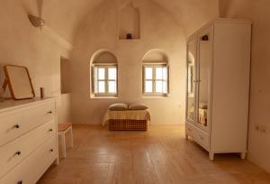 a bedroom with a bed and two windows at Castelli Loggia in Emporio Santorini