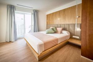 a bedroom with a large white bed with a window at Hostal Pericón in Conil de la Frontera +22 photos