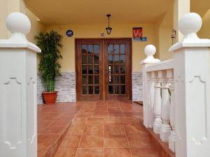 a hallway with a wooden door and a plant at Vv Casa Maruca Accesibilidad - Playa 5 min in Caleta De Fuste