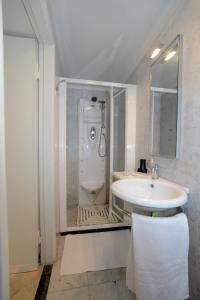 baño blanco con ducha y lavamanos en A Quattro Passi Dalle Mura, en Lucca