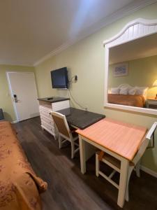 um quarto com uma secretária, uma cama e um quarto em American Inn - Grover beach - Pismo Beach em Grover Beach