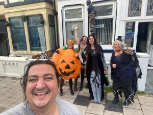 a group of people posing for a picture with a pumpkin costume at White Moon Hotel in Blackpool
