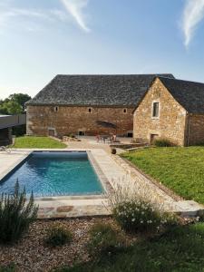 un granero con piscina frente a una casa en Gîte Le Marronnier - La Planhe, en Bozouls