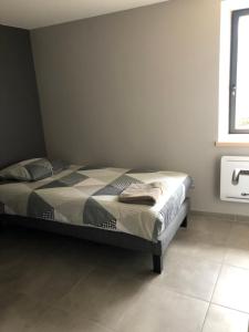 1 dormitorio con 1 cama en una habitación con ventana en Gîte Le Marronnier - La Planhe, en Bozouls