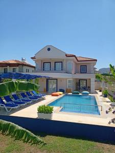 a villa with a swimming pool and chairs at Rota Villalari in Dalyan