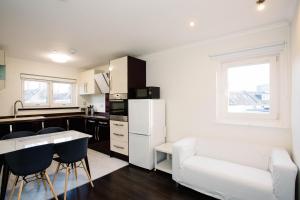a kitchen with a white refrigerator and a table and chairs at 2 DoubleBed Rooms Flat Aberdeen City, near University in Aberdeen
