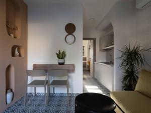 eine Küche und ein Wohnzimmer mit einem Tisch und Stühlen in der Unterkunft Asimina Suites in Nikiti