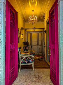 Habitación con puertas rosas, silla y lámpara de araña. en Variante Hotel en Konak